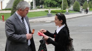 Девочка раздает георгиевские ленты на улице Душанбе